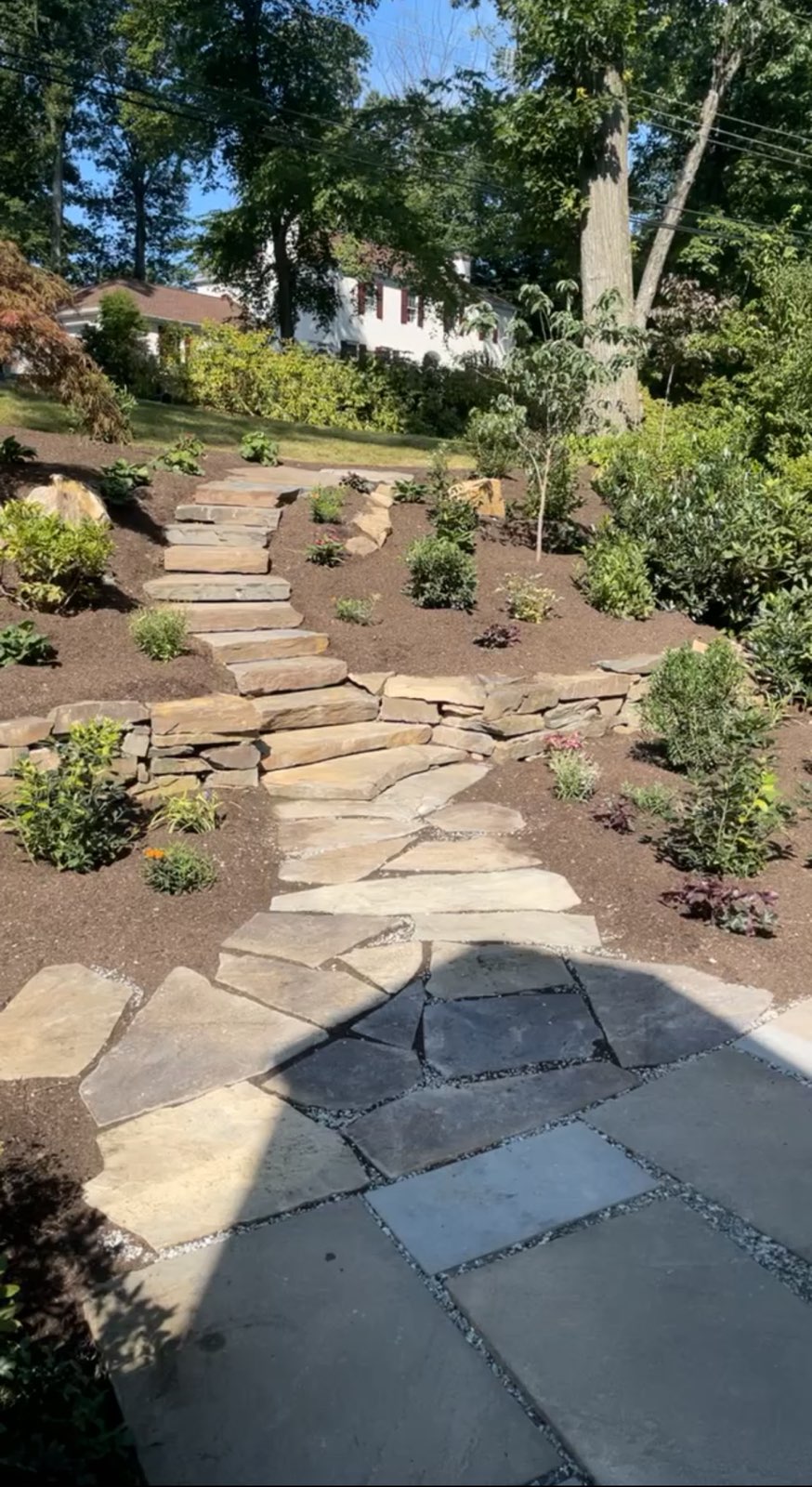 Natural stone path and retaining wall with landscaped garden beds
